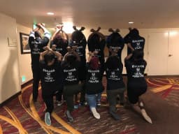 Group wearing custom "Wakanda Forever" t-shirts, shown from behind