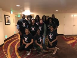 Group wearing custom black "To Whom Much Is Given, Much Is Expected" t-shirts
