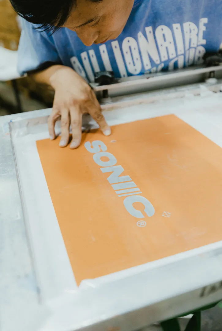 Custom screen printing service applying ink for screen printing shirts