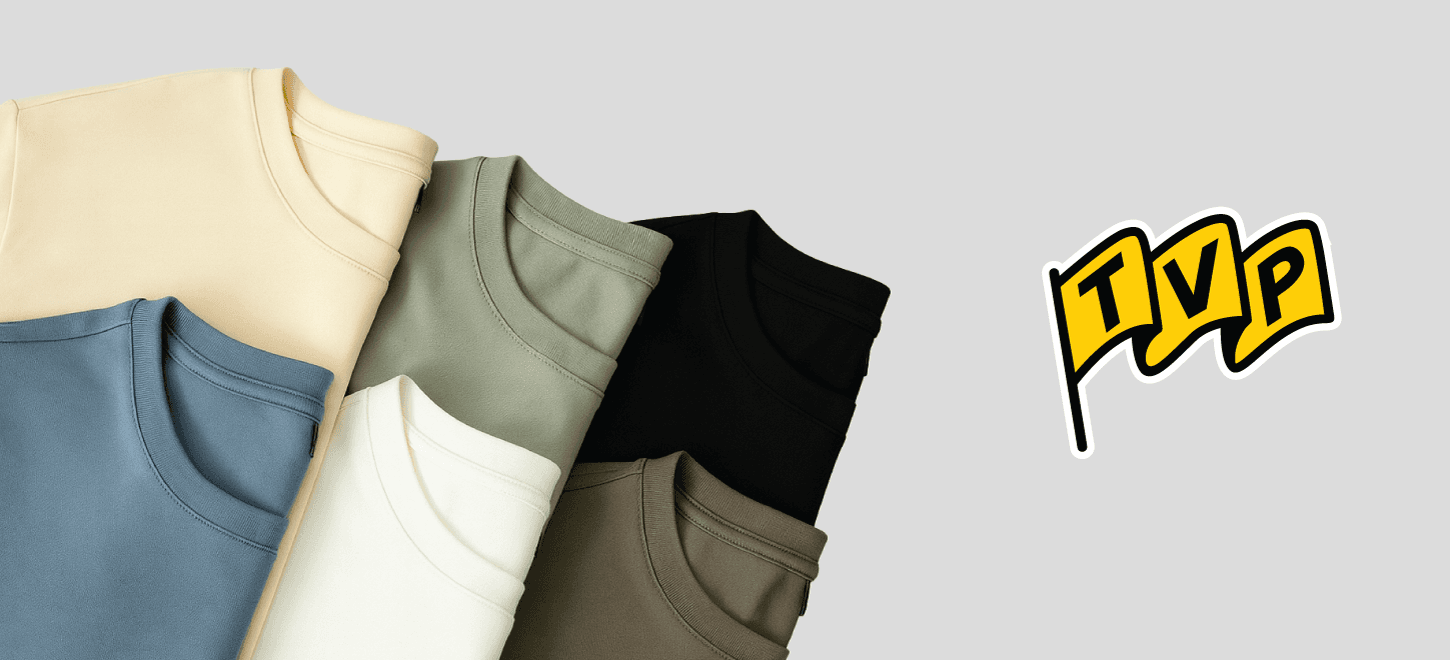 How can shirts tell your brand's story using color and branding? Neatly folded t‑shirts in assorted colors with TVP logo, showcasing apparel variety for brand identity.