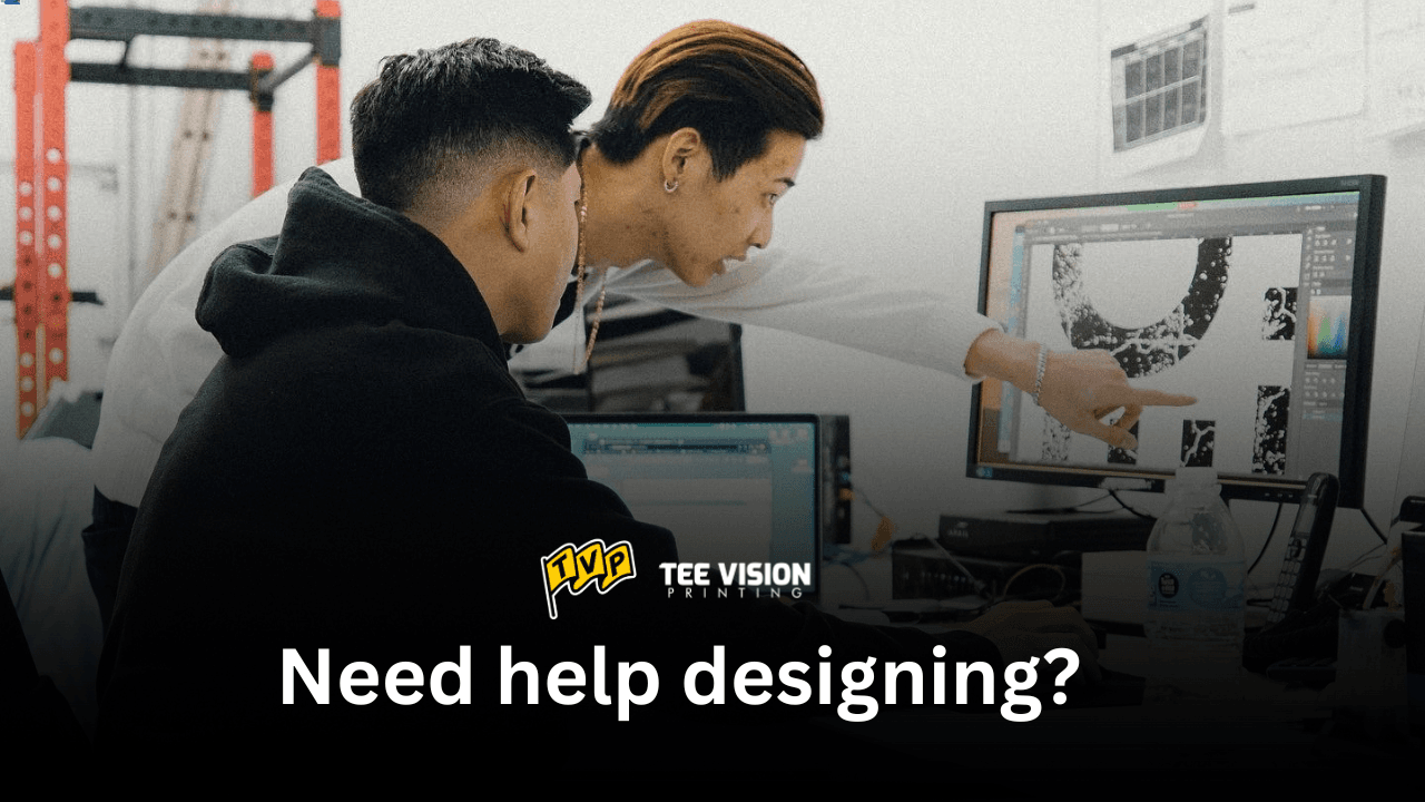 Two people collaborating on a computer graphic, highlighting the design support available when choosing which fit style is best for your merch.