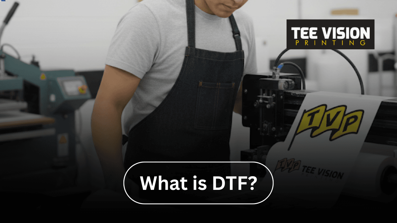 Technician operating a DTF printer with transfer film, demonstrating what’s the difference between DTF and DTG printing methods in garment decoration.