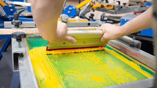 Screen printing in action, showcasing the craftsmanship behind Martin Armini's custom printed merch production.