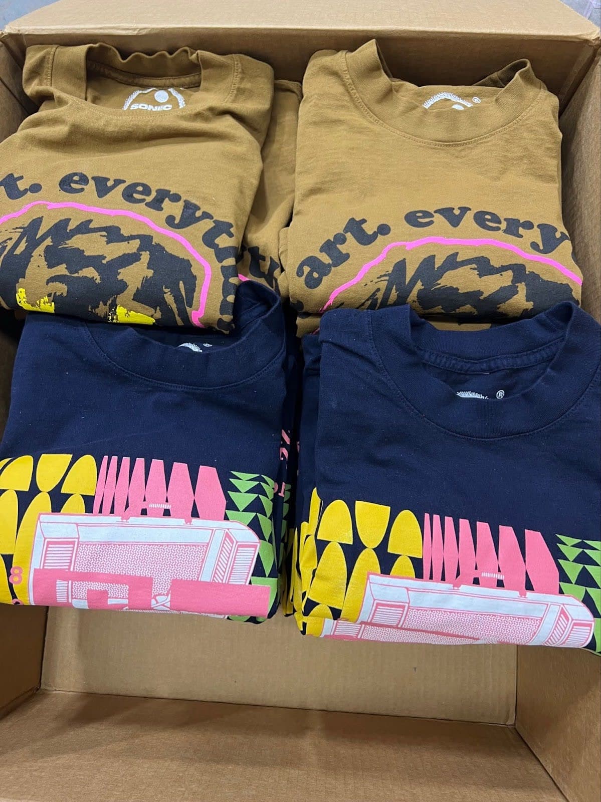 Embroidery vs. Screen Printing visual—folded graphic t-shirts featuring vibrant printed designs, illustrating the color flexibility of screen printing.