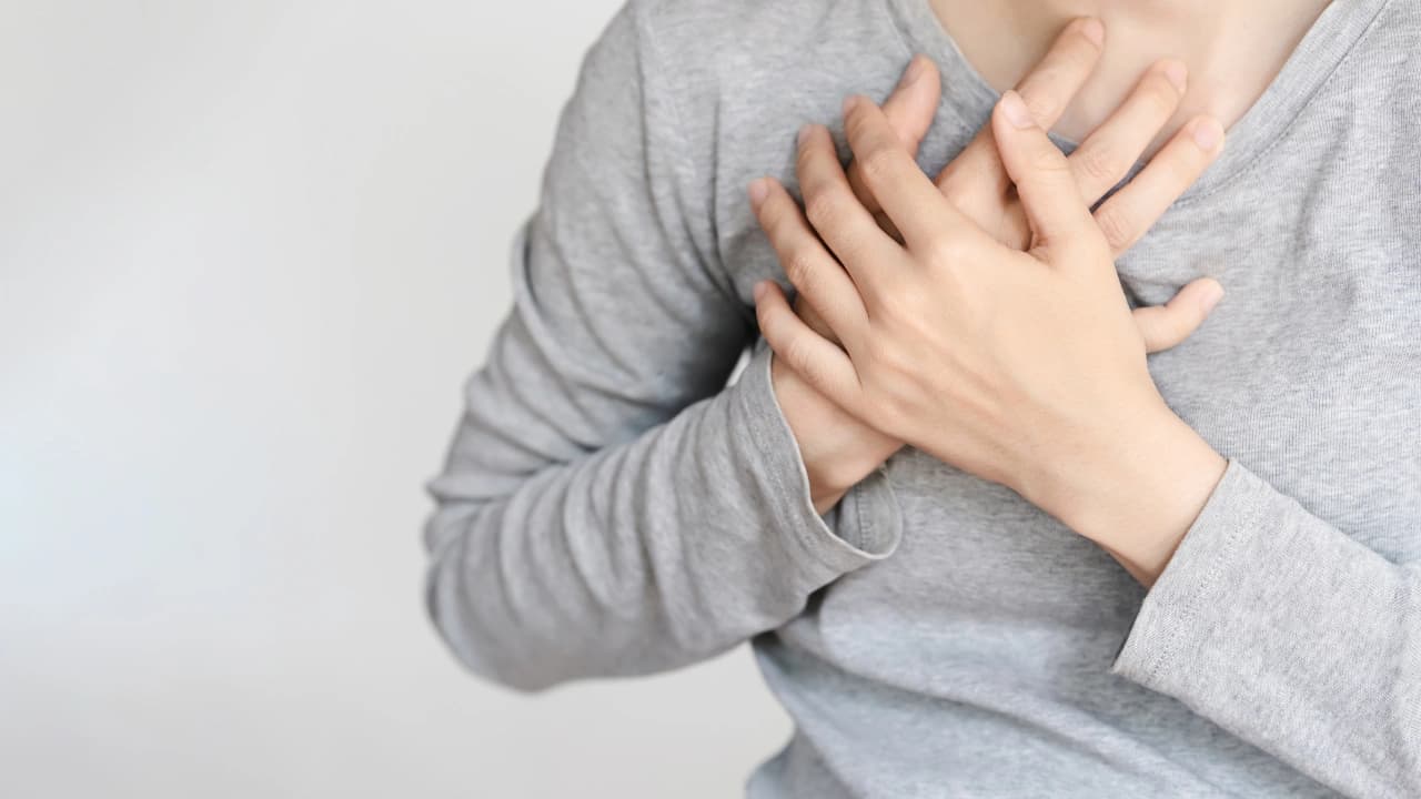 A person wearing a comfortable gray t-shirt with hands on chest, emphasizing the feel of custom t-shirt design.