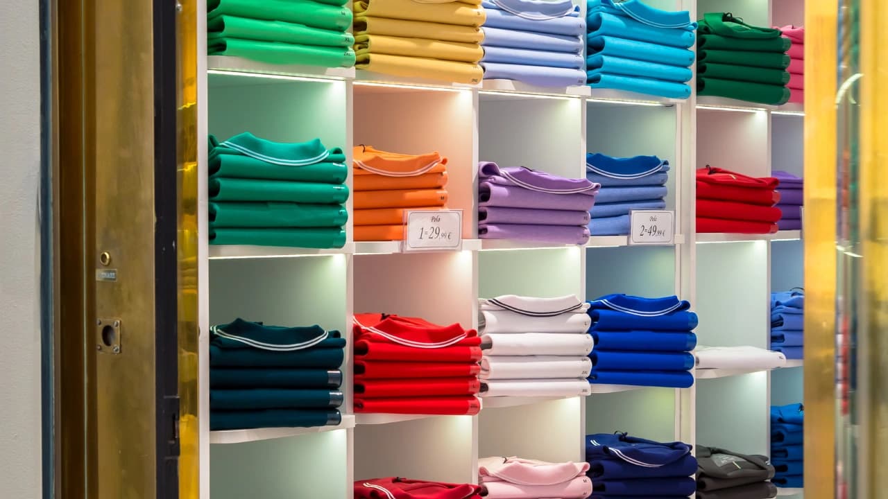 Wall display of colorful shirts available for custom t-shirt design wholesale, perfect for bulk screen print shirt orders.