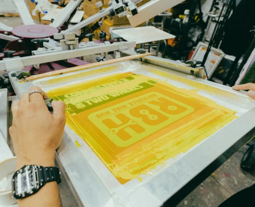 Multi-color screen printing in progress at our Philadelphia shop, showing precision registration of different ink layers on custom apparel