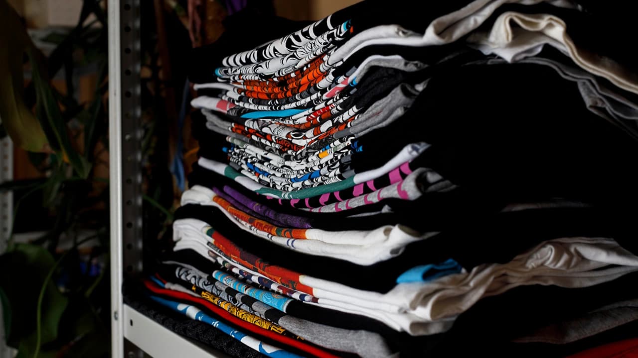 Stacks of finished graphic design apparel on our shelves, ready to fulfill your custom t-shirt design wholesale order.