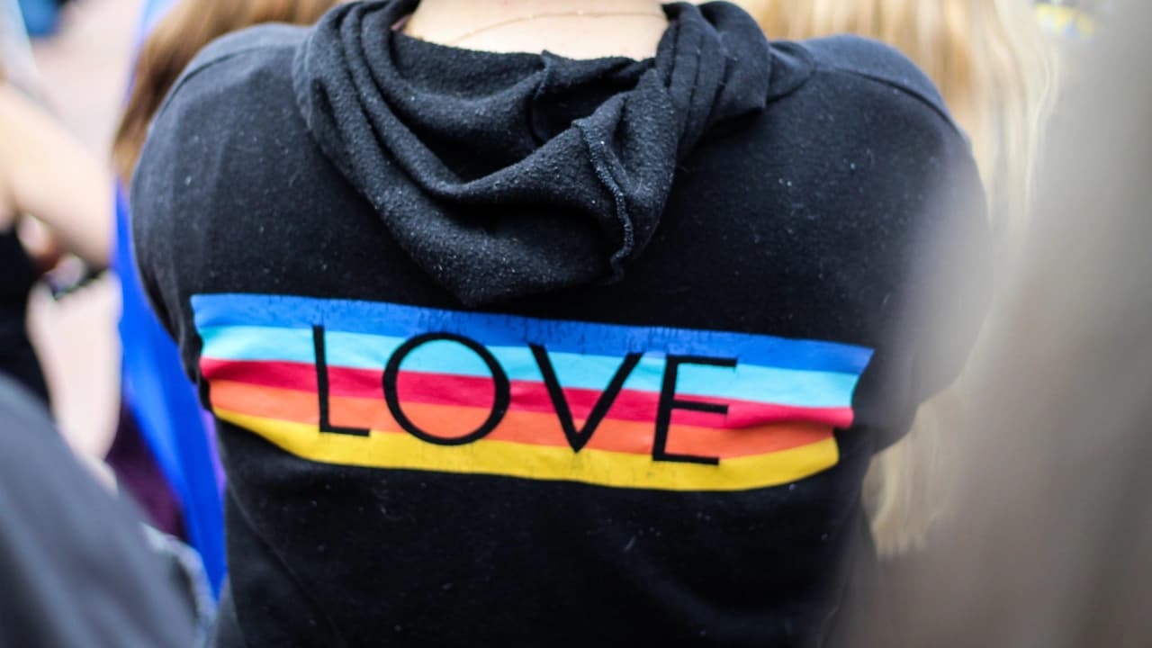 Our apparel design services create impactful graphic design apparel, like this 'LOVE' hoodie with a vibrant rainbow.