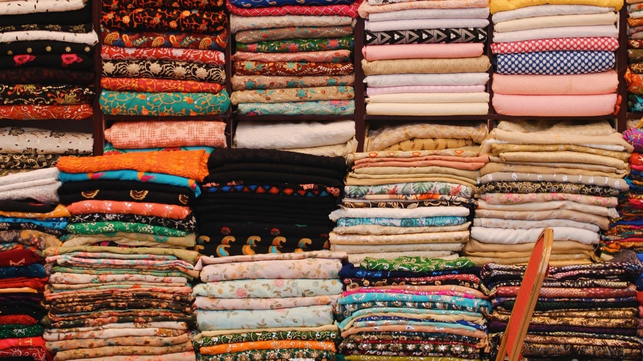 Vast piles of diverse, colorful fabrics, perfect for custom t-shirt design and creating unique apparel.