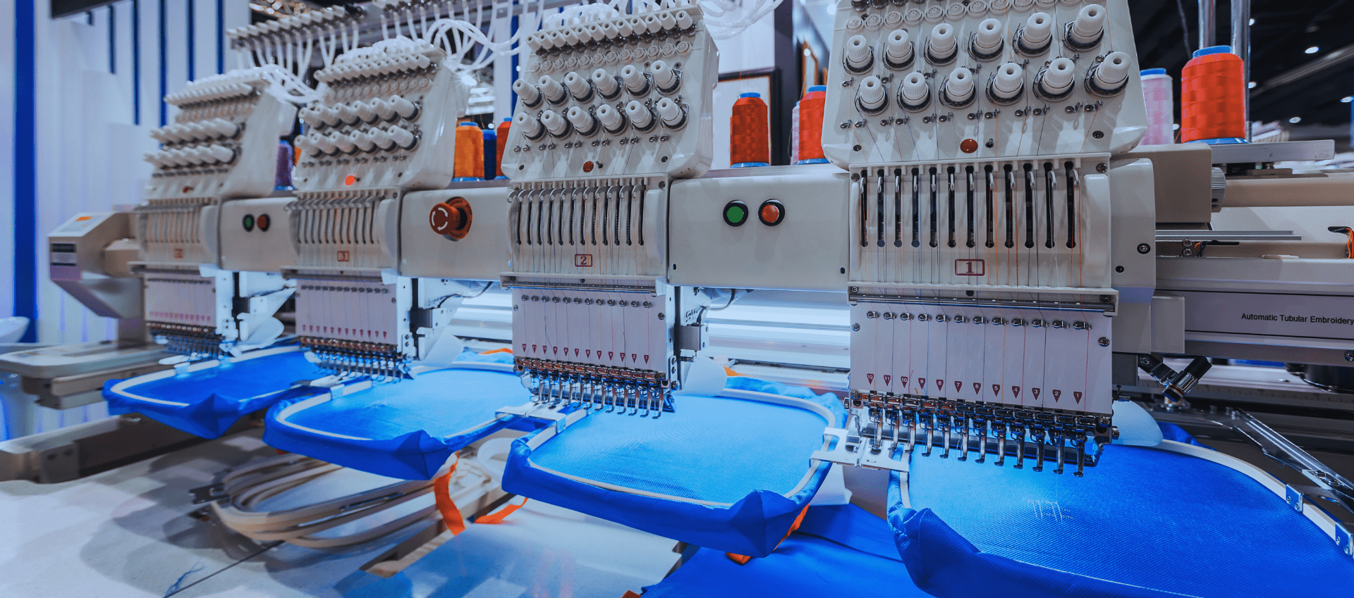 Multiple embroidery machines working on t-shirt designs, ideal for custom t-shirt design and bulk production.